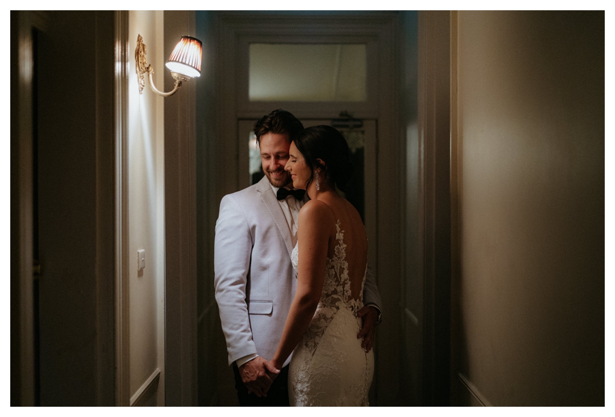A newly wedding couple hugging in some moody light at their South Coast Ravensthorpe Guesthouse wedding