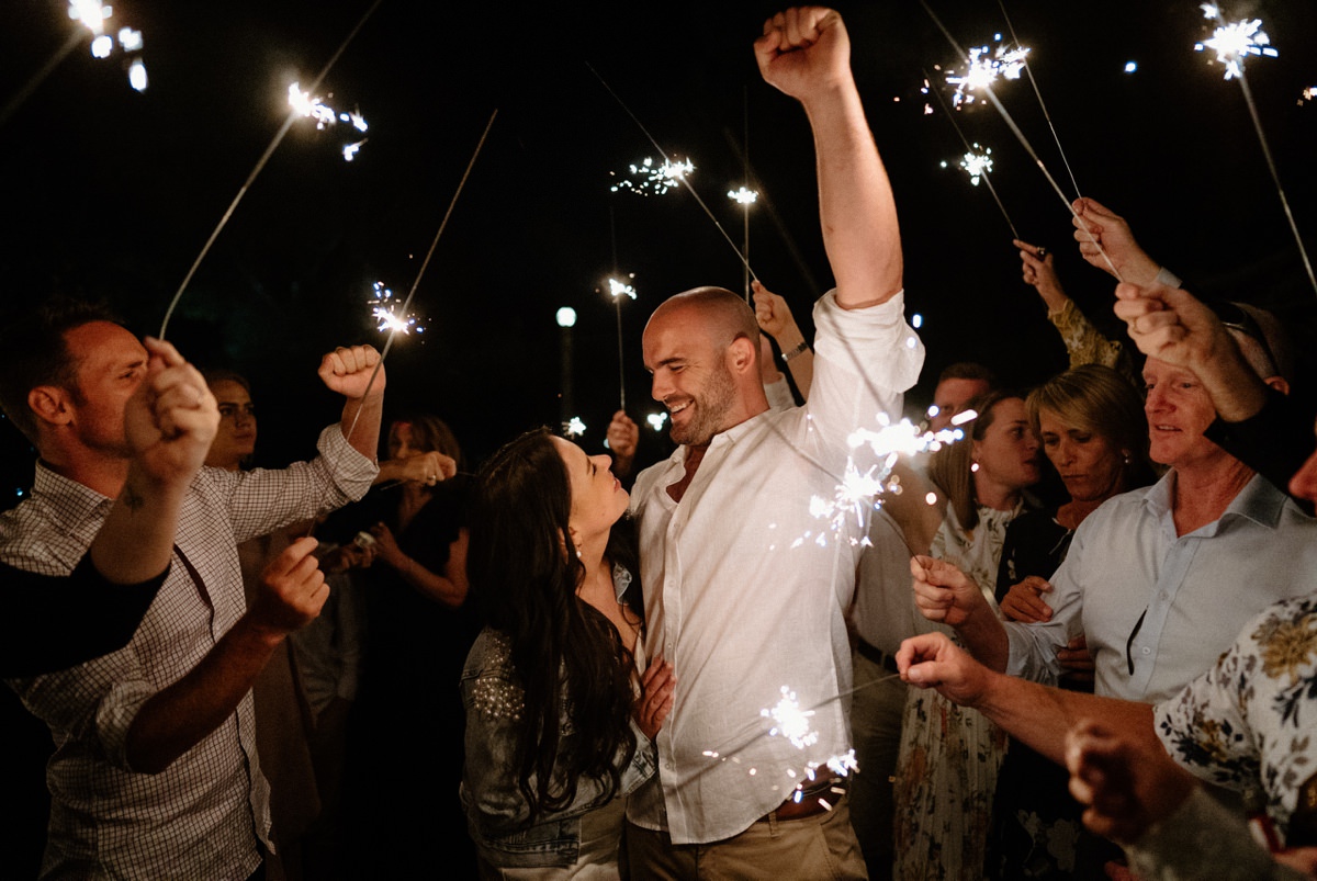 A newly wed couple getting a sparkler send off at their driftwood shed wedding.