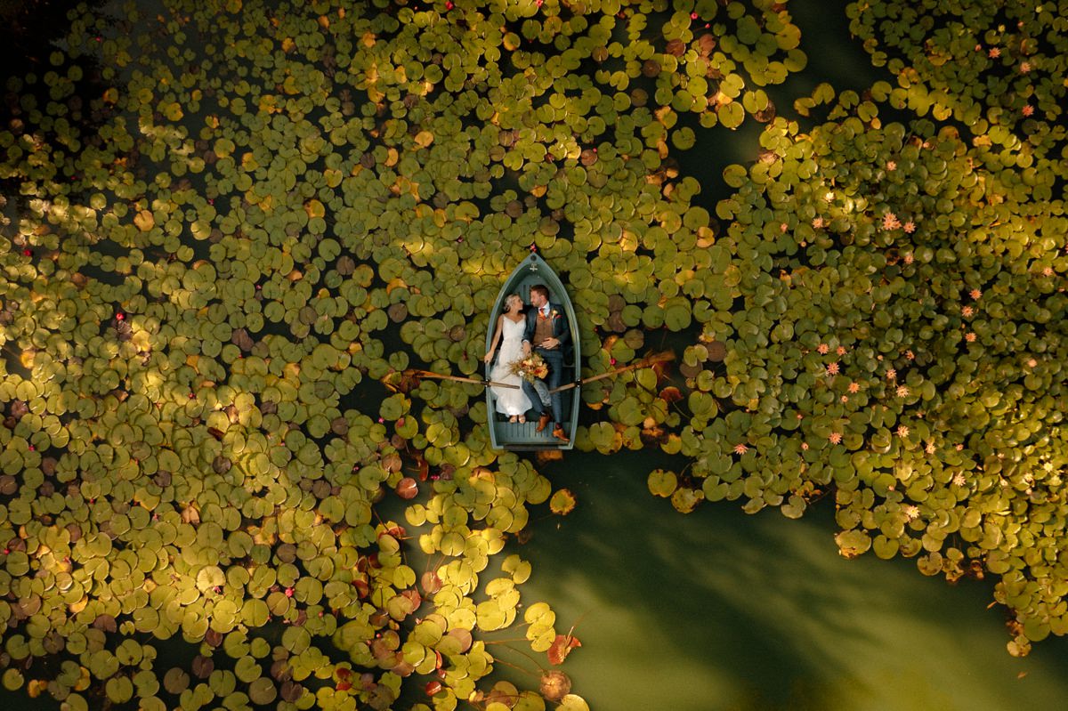 a couple in a boat using a drone at their bodycotts lane wedding