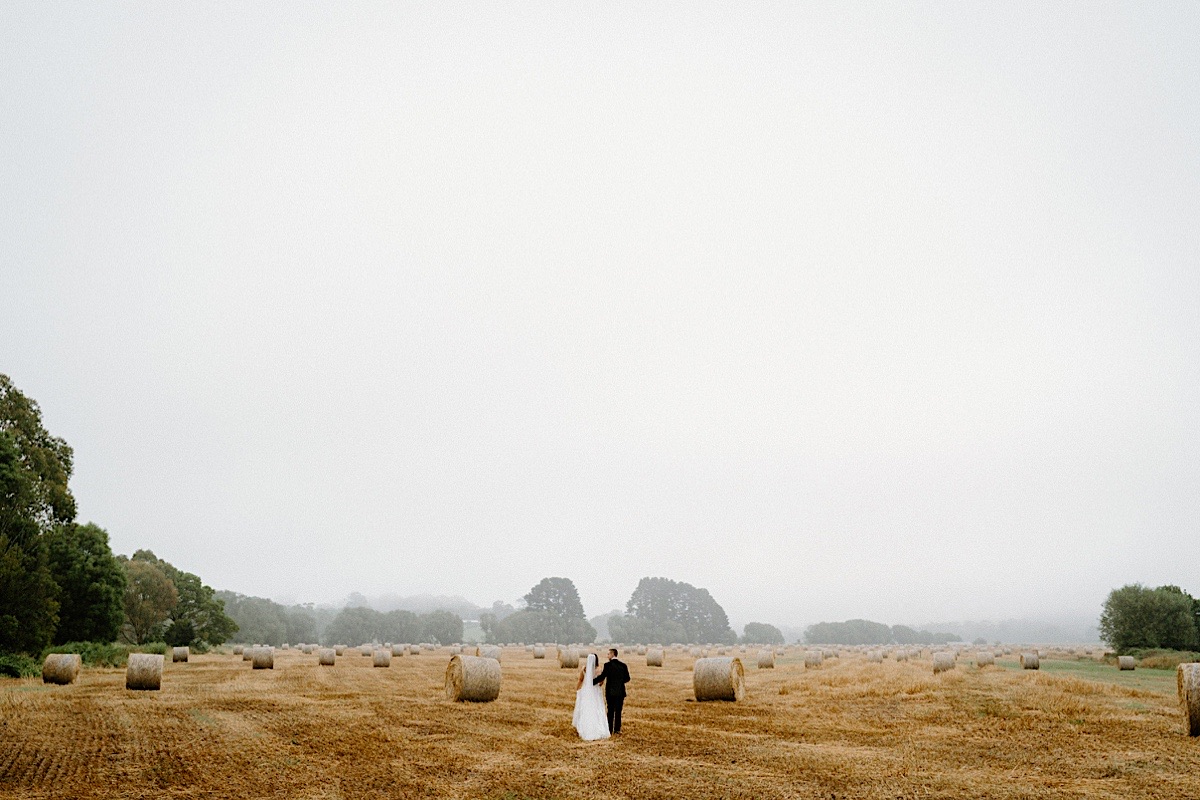 A newly wed couple walking in a field at their Southern Highlands Bodycotts Lane elopement.
