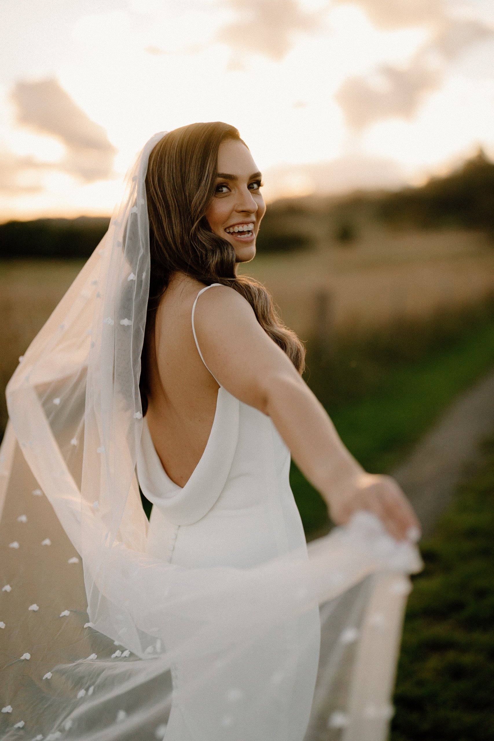 a beautiful bride walking towards the sunset at The Stables, Bendooley Estate wedding.