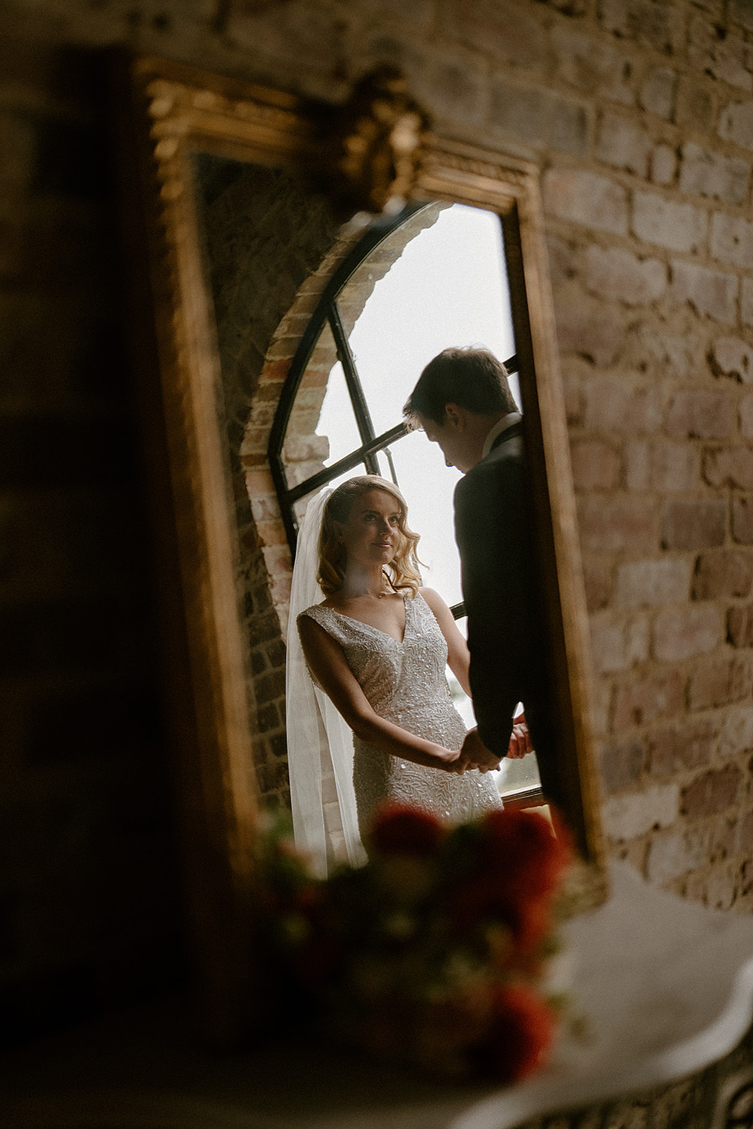 Two people photographed from a reflection in a mirror at their Mali Brae wedding.