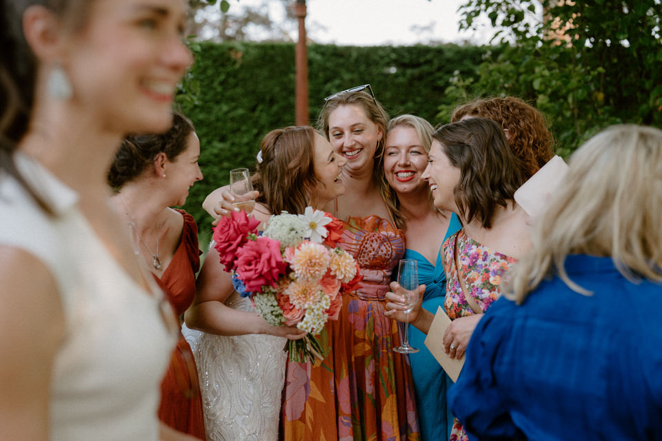 A bride with her guests, all wearing colourful dress and in good spirits at The Homestead, Berry.