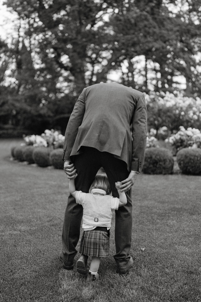 A touching image of a grandfather teaching his grandson how to walk. It's in black and white.
