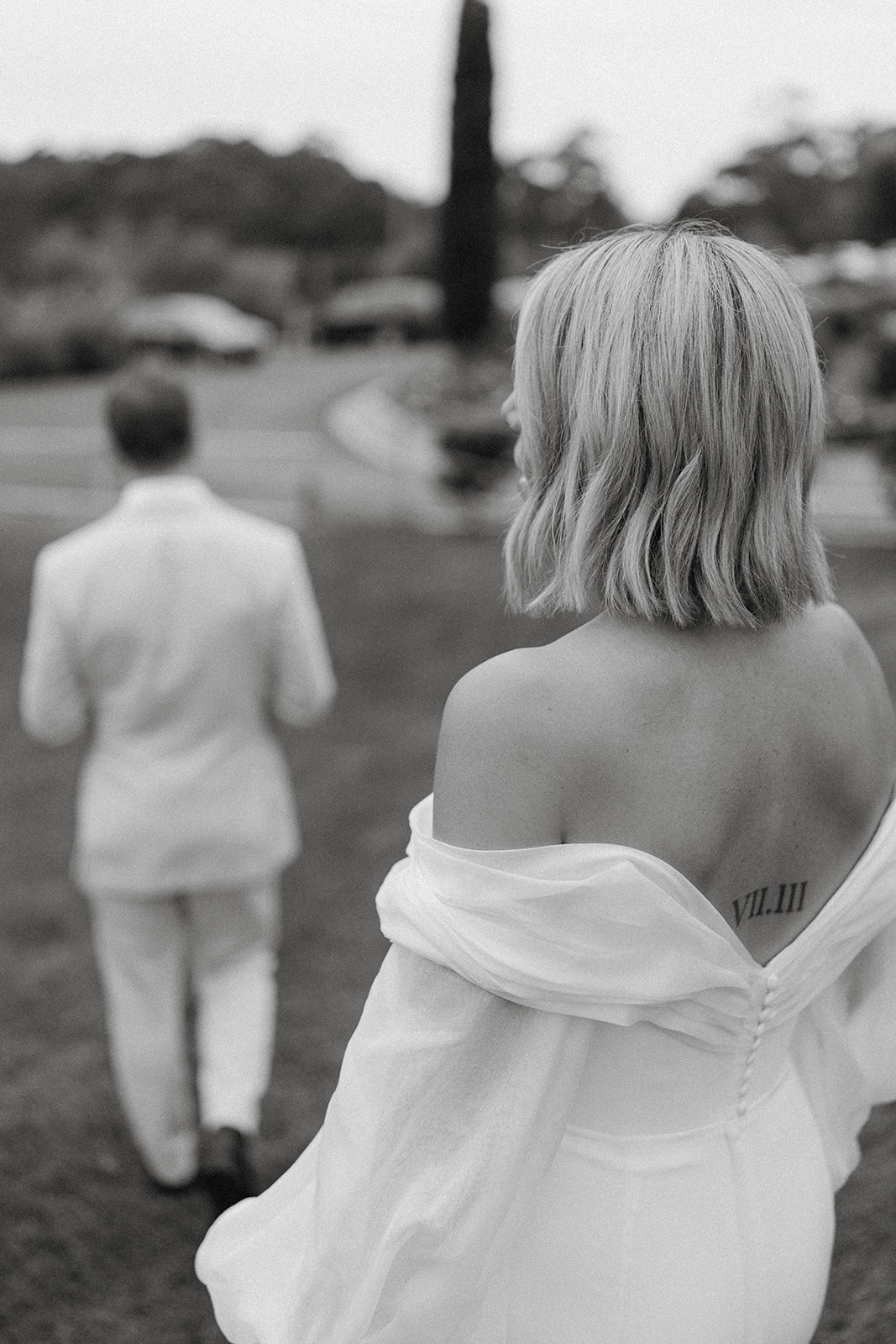 A black and white photograph taken from behind a bride with a nice back of her wedding gown at her cupitts winery wedding.